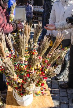 people buy traditional floral natural palm decorations for money in outdoor spring market fair event.