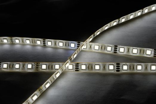 white led strip with a glue layer, background in the dark, illuminated by strip