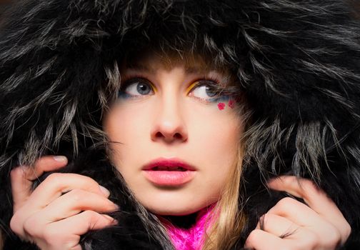 Closeup portrait of young woman in fur hood