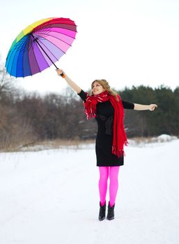 Young woman with multicolor umbrella at forest