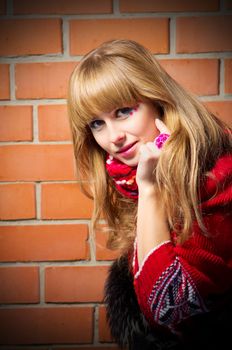 Fashion portrait of young woman on red brick wall background