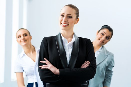 successful business woman in the office, colleagues stare over his shoulder