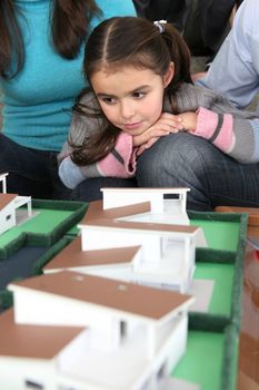 Young family sat with scale model of new home