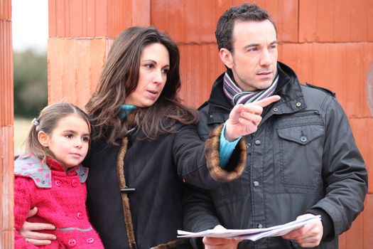 family looking at the plan of their future house