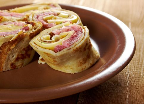 rolled pancakes stuffed ham and cheese. Shallow depth-of-field.