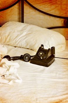 Vintage bakelite phone on white sheets textured style.