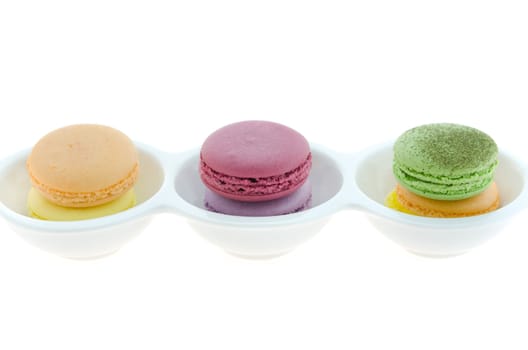 French macaroons stack  in bowl over white background