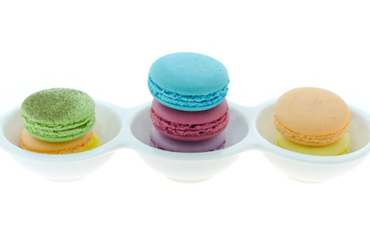 colorful of French macaroons stack  in bowl over white background