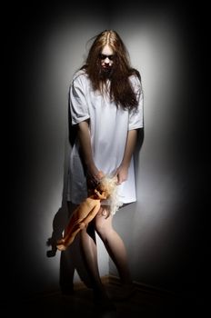 Zombie girl holding plastic doll