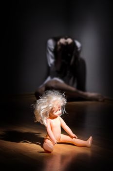 Crazy girl and plastic doll on the floor