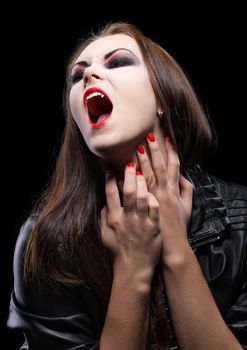 Young beautiful vampire woman on black