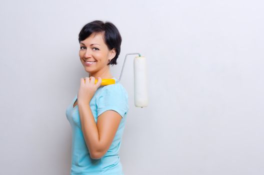 Smiling woman with painting roller