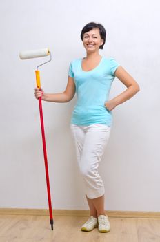 Young smiling woman with painting roller