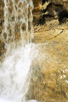 The flow of water falls with solar flares falling from a rock