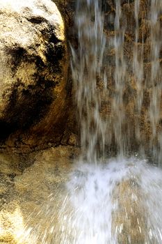 The flow of water falls with solar flares falling from a rock