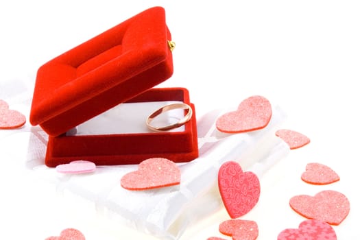 Red gift box with yellow gold wedding ring on white background