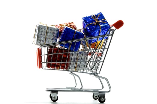 shopping cart with gift box wrapped in colored paper and ribbon on white background