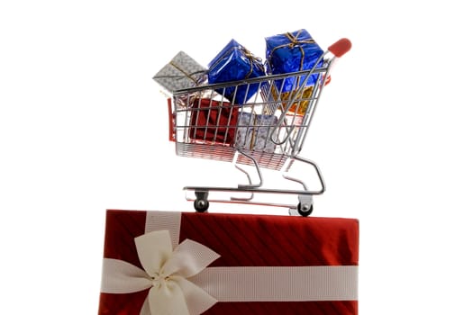 shopping cart with gift box wrapped in colored paper and ribbon on white background