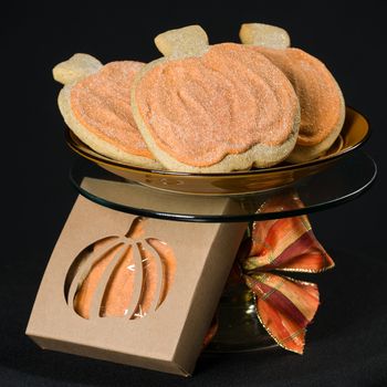 Homemade pumkin cookies on isolated black background.