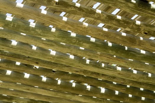 Stylized wooden pergola roof against the blue sky is visible through the roof structure pergolas