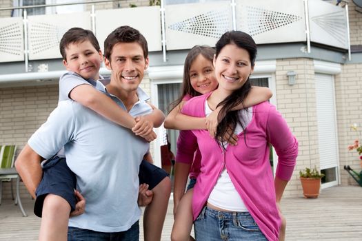 Portrait of happy family having fun outdoors at their home