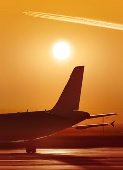 big passenger airplane is waiting for departure in airport, sunset