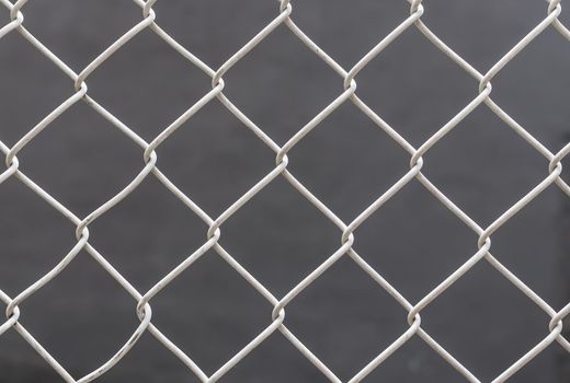 White chain link fence on gray background