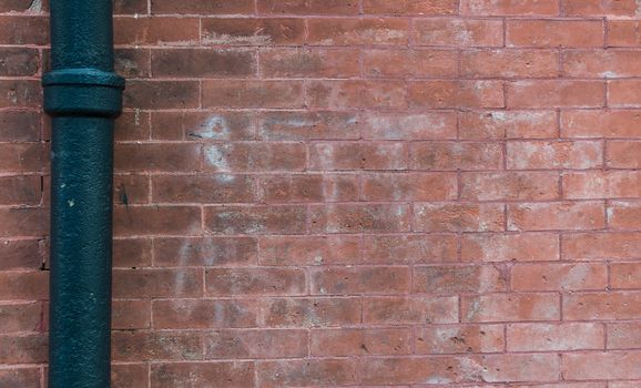 Red rough brick wall with steel pipe background