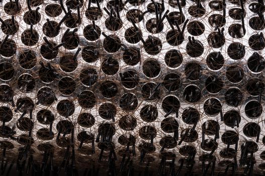 Close up macro shot of hairy hairbrush with brown hair.