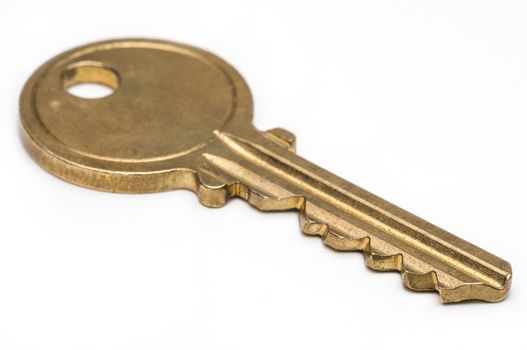 Yellow brass key on isolated white background.