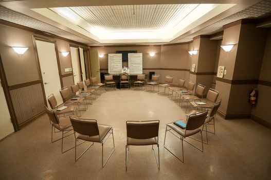 12 step recovery meeting room with chairs and signs.