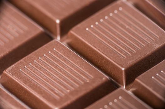 Macro shot of dark chocolate bar cubes.