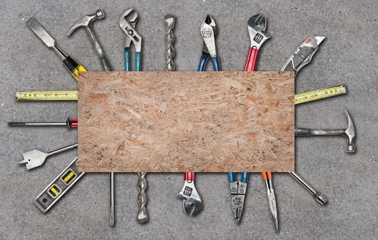 Various used tools on concrete background with wood