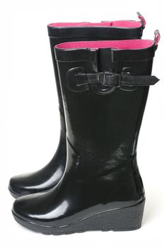 black rubber boots on white background with pink insides.