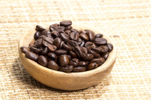 Fresh roasted coffee beans on light textured surface
