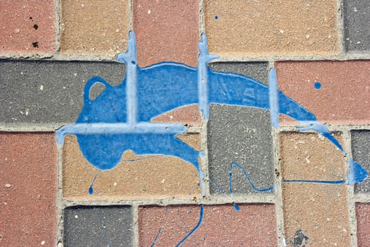 The texture of the pavement, lined red-brown, dark gray and orange brick with a spot of dry bright blue paint. Abstract background for graphic design