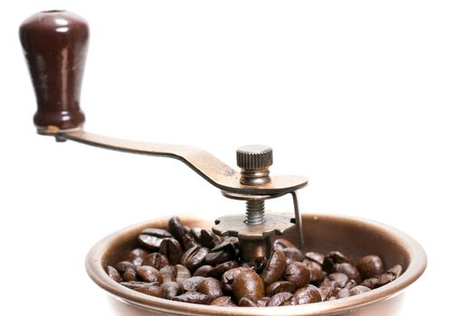 Fresh roasted coffee beans in the manual coffee grinder on white background