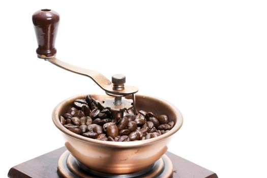 Fresh roasted coffee beans in the manual coffee grinder on white background