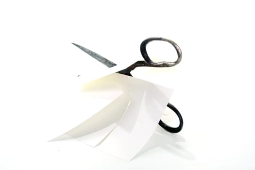 Old rusty steel scissors cut paper on white background