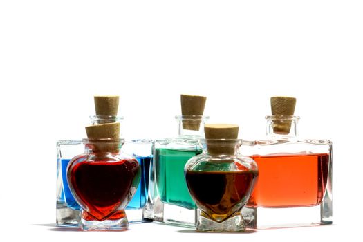 Clear glass vials filled with red, green and blue liquid on a white background