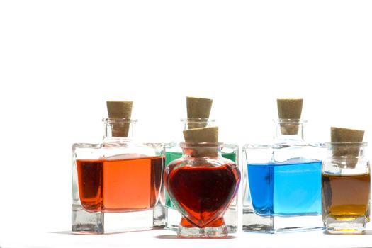 Clear glass vials filled with red, green and blue liquid on a white background