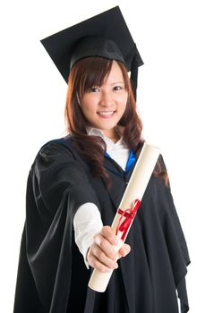 Portrait of smiling Asian female student in graduate gown showing graduation diploma isolated on white background
