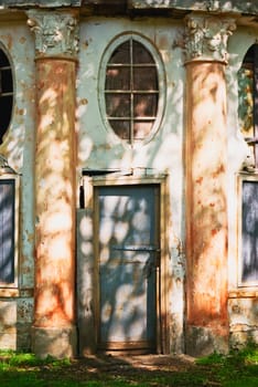 Old wooden door on abandoned  house with columns