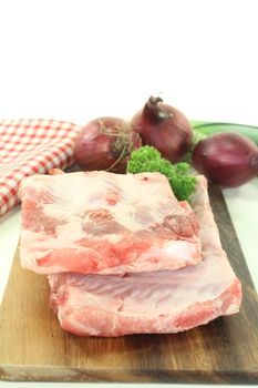 Beef spare ribs with parsley and onions on a wooden board