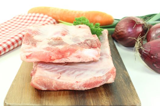 Beef spare ribs with parsley and leek on a wooden board