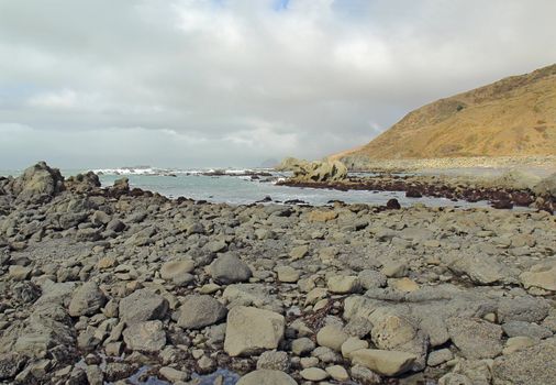 A rocky beach off of Mattole Road on the Lost Coast of California with breaking surf and a cloudy sky