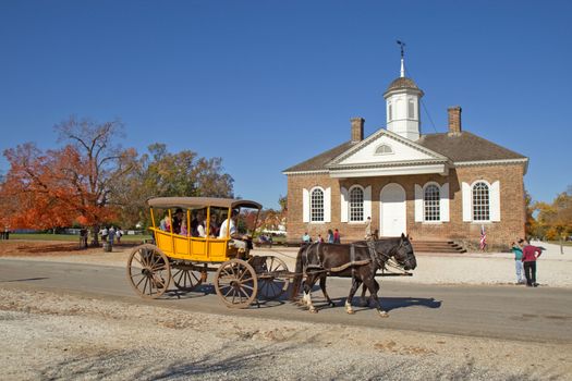 WILLIAMSBURG, VIRGINIA - NOVEMBER 9: A horse-drawn carriage rides by the courthouse in Colonial Williamsburg, a major attraction for tourists and meetings of world leaders, on November 9, 2011.