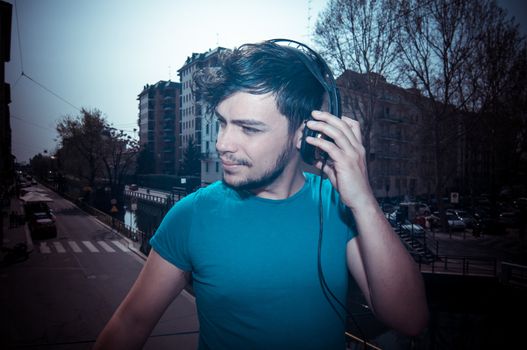 young man hipster listening to music with headphones