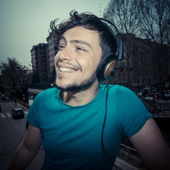 young man hipster listening to music with headphones
