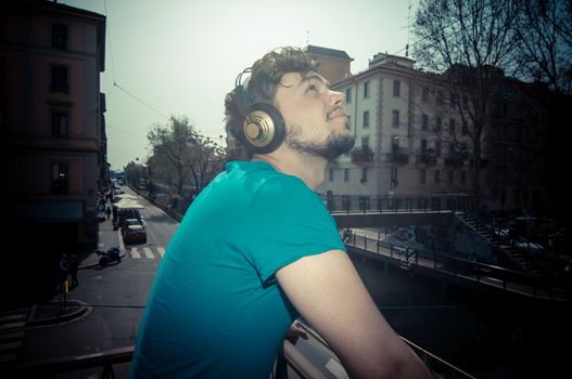 young man hipster listening to music with headphones